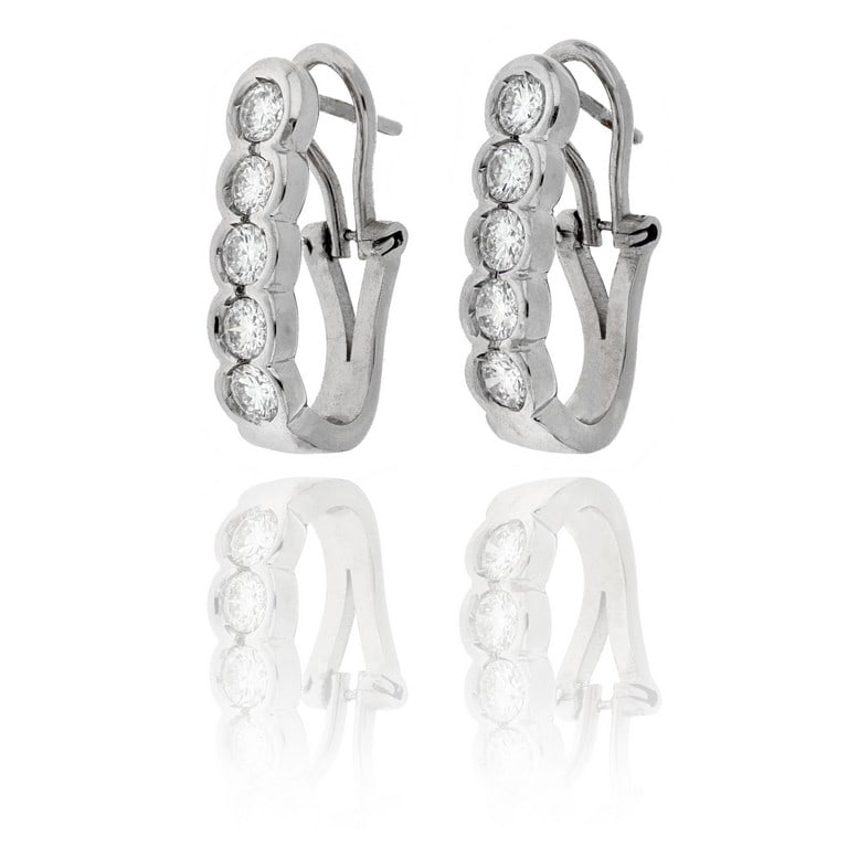 Orecchini in oro bianco a clips, 5 diamanti: Orecchini in oro bianco a clips, 5 diamanti taglio brillante contornano il lobo con questa sportiva lavorazione in lastra lobata a modello "Riviere", ct. 1,70 ca. Dimensioni 2,5 x 0,7 cm. Peso 12,0 g.