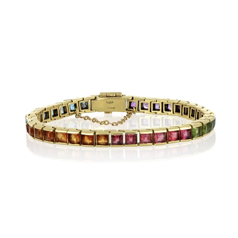 Bracciale tennis multicolor in oro giallo con: Bracciale tennis multicolor in oro giallo con gemme di colore taglio carrè. Catenella di sicurezza Lunghezza circa 18 cm. Peso 31,14 g.