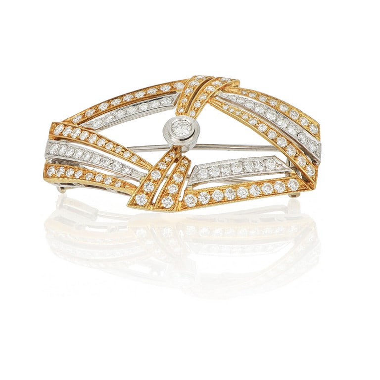 Spilla romboidale in oro giallo e bianco con pavè: Spilla romboidale in oro giallo e bianco con pavè di diamanti e gemma centrale per un totale di 1,30 ct complessivi stimati. Peso 15.85 g.