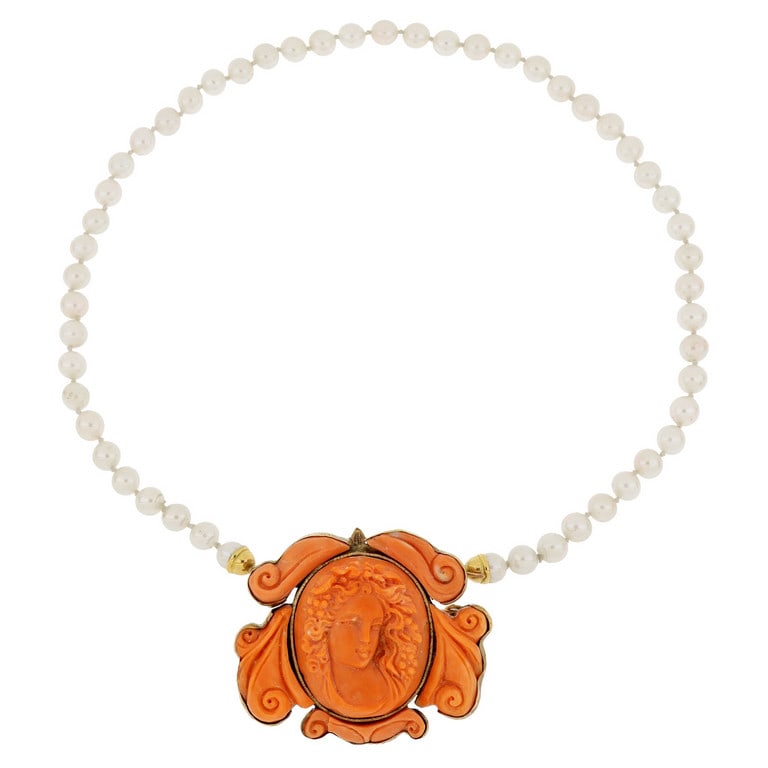 Girocollo di perle giapponesi coltivate, 6,5/7 mm: Girocollo di perle giapponesi coltivate, 6,5/7 mm di diametro, al centro, come chiusura, un grande medaglione in oro giallo 14k di antica manifattura, con 6 piastre di corallo finemente inciso a volut