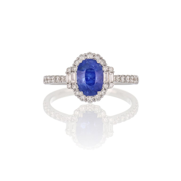 Anello halo in oro bianco con diamanti e zaffiro: Anello halo in oro bianco con diamanti e zaffiro ovale centrale di 2,03 ct di origine birmana, accompagnato da report gemmologico GUILD che ne attesta anche l'assenza di trattamento termico. Misura 13