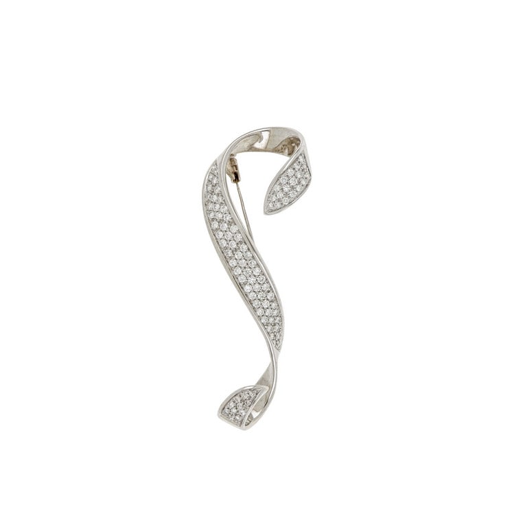 Spilla a nastro, di moderna manifattura in oro: Spilla a nastro, di moderna manifattura in oro bianco tempestata di diamanti taglio brillante su tutta la parte a vista, ct. 2,20 ca. Dimensioni 6,5 x 2,5 cm. Peso 11,30 g.
