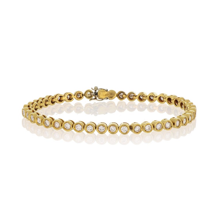 Bracciale "Tennis" in oro giallo e diamanti: Bracciale "Tennis" in oro giallo e diamanti taglio brillante, montati a cipolline cilindriche che si rincorrono al polso, ct. 2,20 ca. Lunghezza 18 cm. Peso 15,25 g.