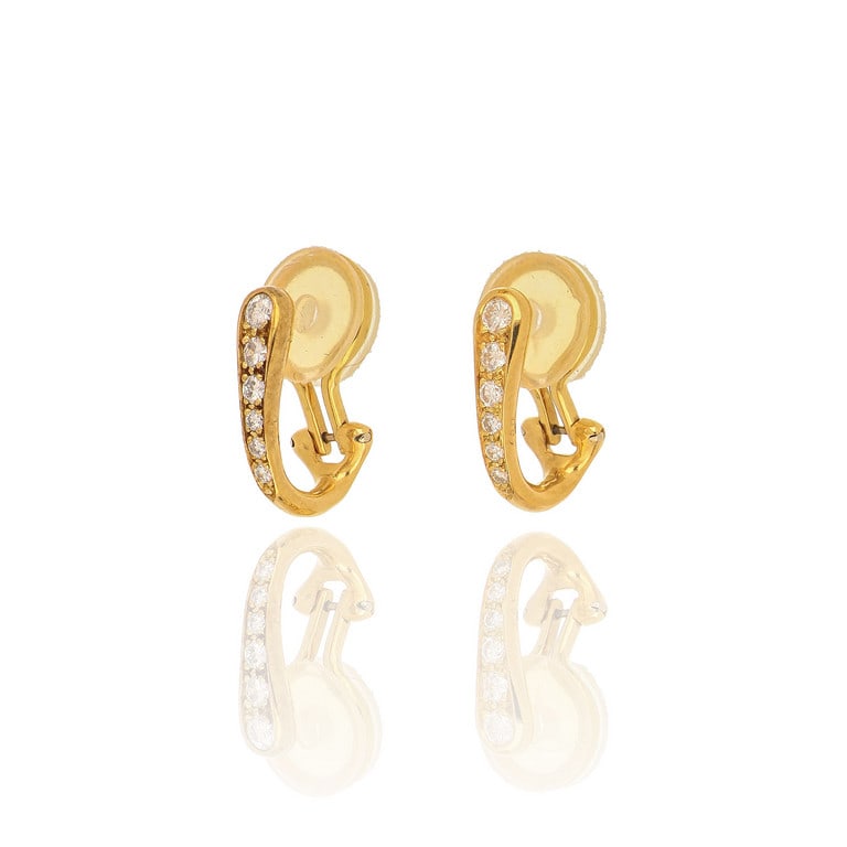 CARTIER - Orecchini in oro giallo a clips,: CARTIER - Orecchini in oro giallo a clips, decorati con una delicata linea di diamanti taglio brillante a scalare, numerati e punzonati, in perfette condizioni. Dimensioni 1,5 cm. Peso 4,10 g.