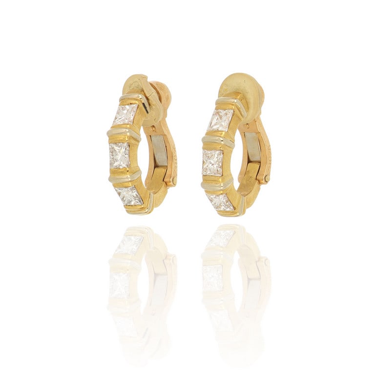 CARTIER - Orecchini in oro giallo in linea con 6: CARTIER - Orecchini in oro giallo in linea con 6 diamanti taglio "Princess" per ct. 1,00 ca. Firma, punzoni e numeri della manifattura sulla chiusura a clips. Dimensioni 1,5 cm. Peso 7,24 g.