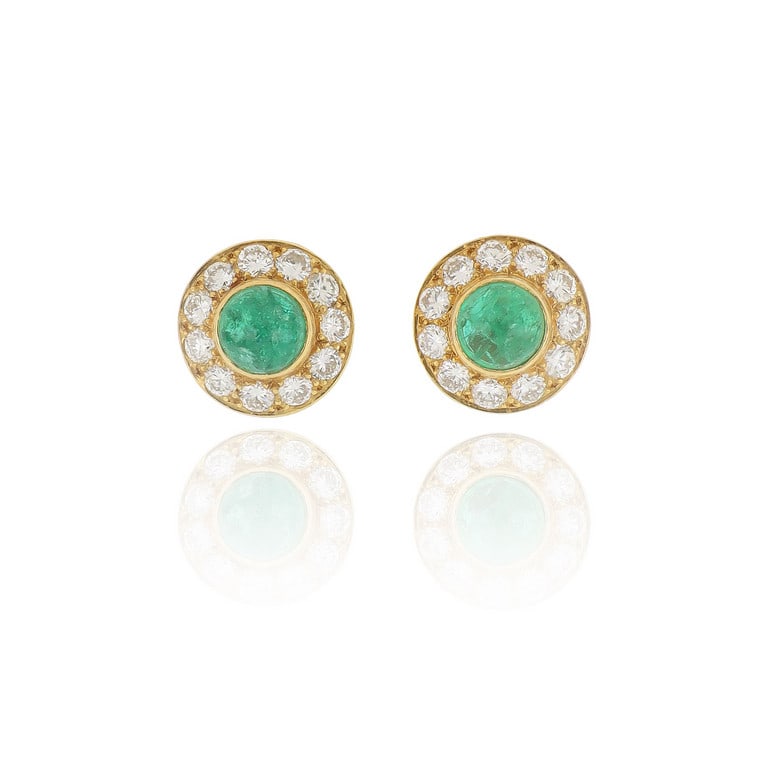 CARTIER - Orecchini in oro giallo a bottone con: CARTIER - Orecchini in oro giallo a bottone con 22 diamanti taglio brillante per ct. 0,70 ca., due smeraldi taglio cabochon al centro. Firma, punzoni e numeri della manifattura sulla chiusura a clips.