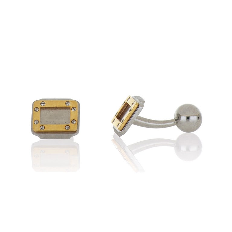CARTIER - Gemelli in acciaio e oro giallo,: CARTIER - Gemelli in acciaio e oro giallo, modello "Santos", punzoni, numeri e marchio della manifattura al retro. Dimensioni 1,5 x 1,2 x 2 cm. Peso 9,58 g.