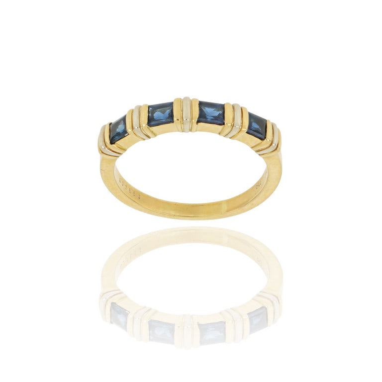 CARTIER - Anello in oro giallo a "Fedina", 4: CARTIER - Anello in oro giallo a "Fedina", 4 zaffiri taglio carrè si rincorrono intercalati da 3 barrette nei colori dell'oro. Punzoni, marchio e numeri nel gambo. Misura n. 20. Peso 5,18 g.