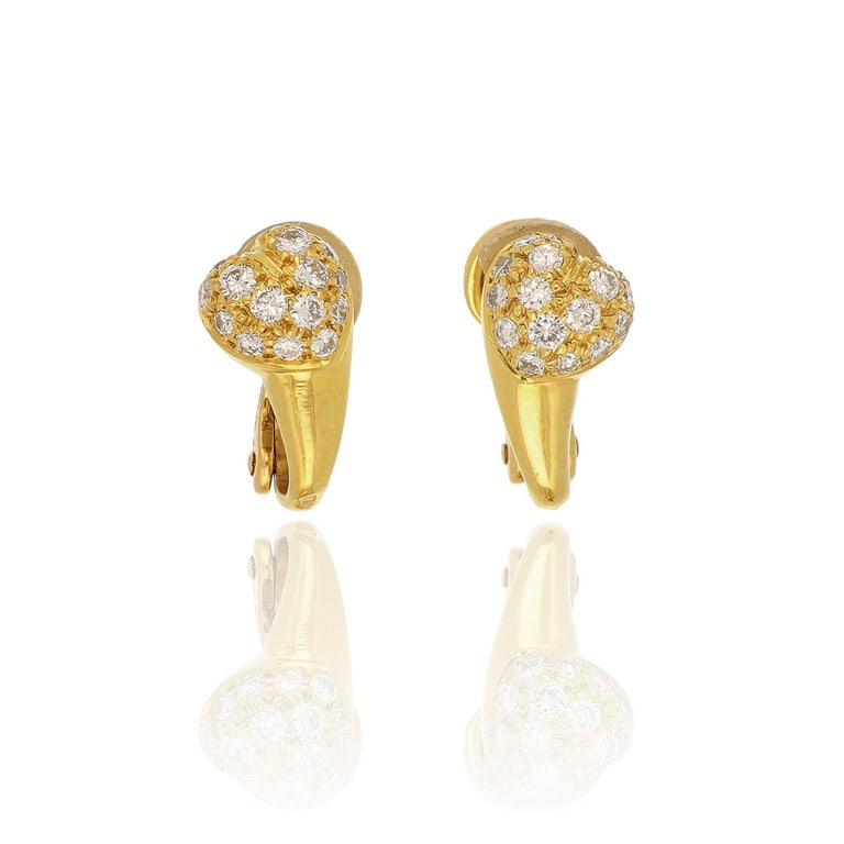 CARTIER - Orecchini in oro giallo a clips, il: CARTIER - Orecchini in oro giallo a clips, il motivo a cuore bombato è impreziosito da un delicato pavè di piccoli diamanti taglio brillante. Dimensioni 1,5 cm, punzoni, firma e numeri della
