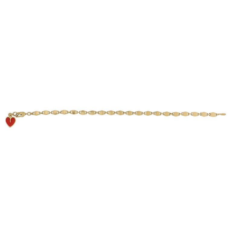 CARTIER - Bracciale in oro giallo con piccolo: CARTIER - Bracciale in oro giallo con piccolo cuoricino smaltato di rosso, la maglia a grani di riso è chiusa da una particolare fermatura a moschettone. Punzoni e firma della manifattura, lunghe