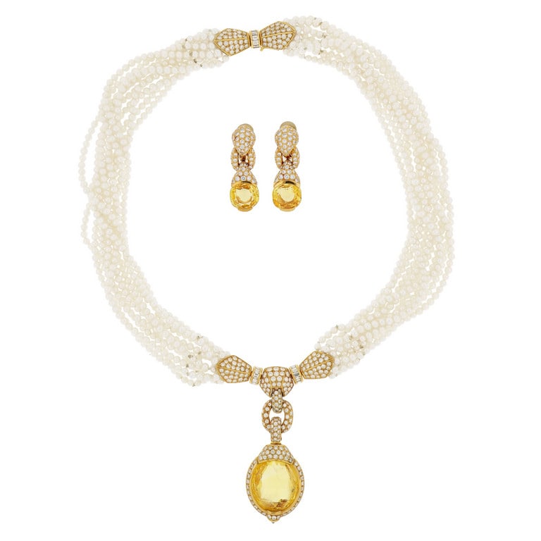 CARTIER - Eccezionale parure in oro giallo, 10: CARTIER - Eccezionale parure in oro giallo, 10 fili di perle fini, 3 mm di diametro, montate a torchon, sostengono un nodo tempestato di diamanti, taglio brillante e baguette, al centro un grande zaff