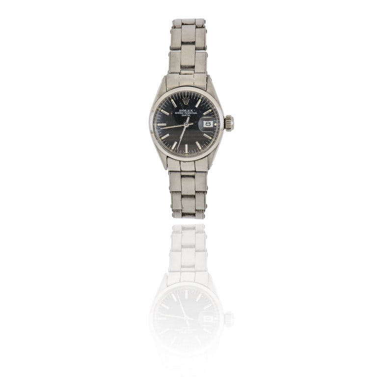 ROLEX - Orologio per signora in acciaio con: ROLEX - Orologio per signora in acciaio con bracciale, modello "Date", vetro plastica, quadrante nero, indici a barretta, piccolo datario a ore 3, movimento meccanico a carica automatica. Diametro 24 