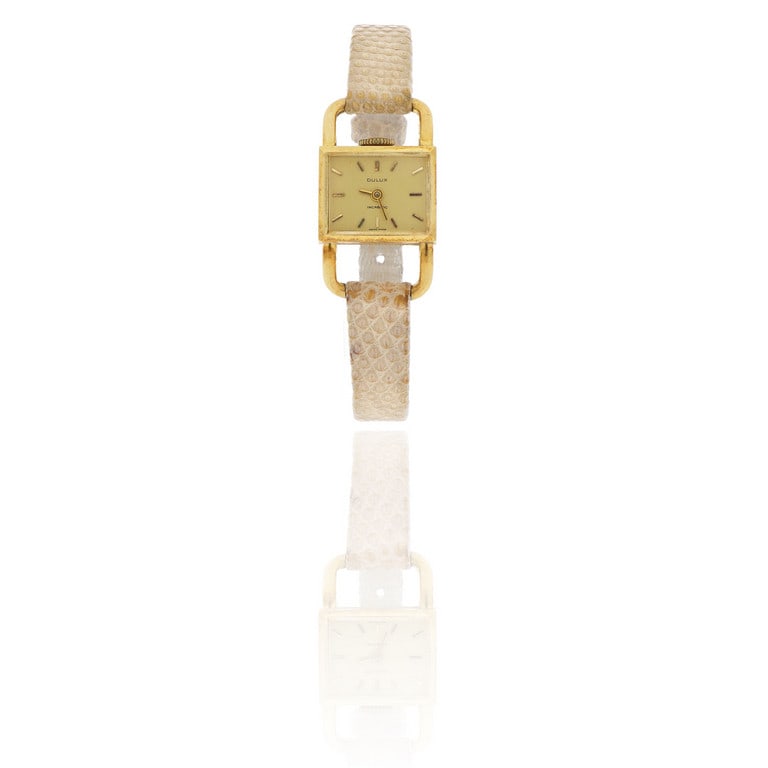 DULUX - Orologio modello "Lucchetto" in oro: DULUX - Orologio modello "Lucchetto" in oro giallo con movimento meccanico a carica manuale, cinturino in pelle e fibbia non originale. Misure 3 x 2 cm. Peso 14,0 g.