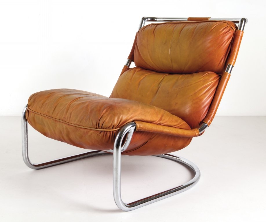 UNA POLTRONA, anni '70. Tubo di acciaio: UNA POLTRONA, anni '70. Tubo di acciaio cromato, imbottitura rivestita in pelle. Altezza cm 77, larghezza 70, profonditÃ 94.