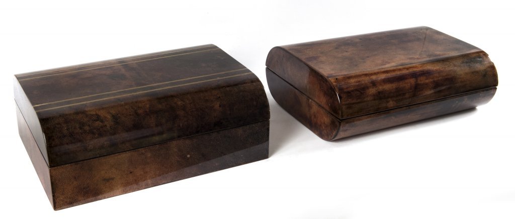 TURA Due scatole portagioie, anni "70 Una: TURA Due scatole portagioie, anni "70 Una legno rivestito in pergamena color tabacco,rifinita in poliestere. L'altra in legno rivestito in pergamena color tabacco con inserti in ottone. Misure: cm 9(h