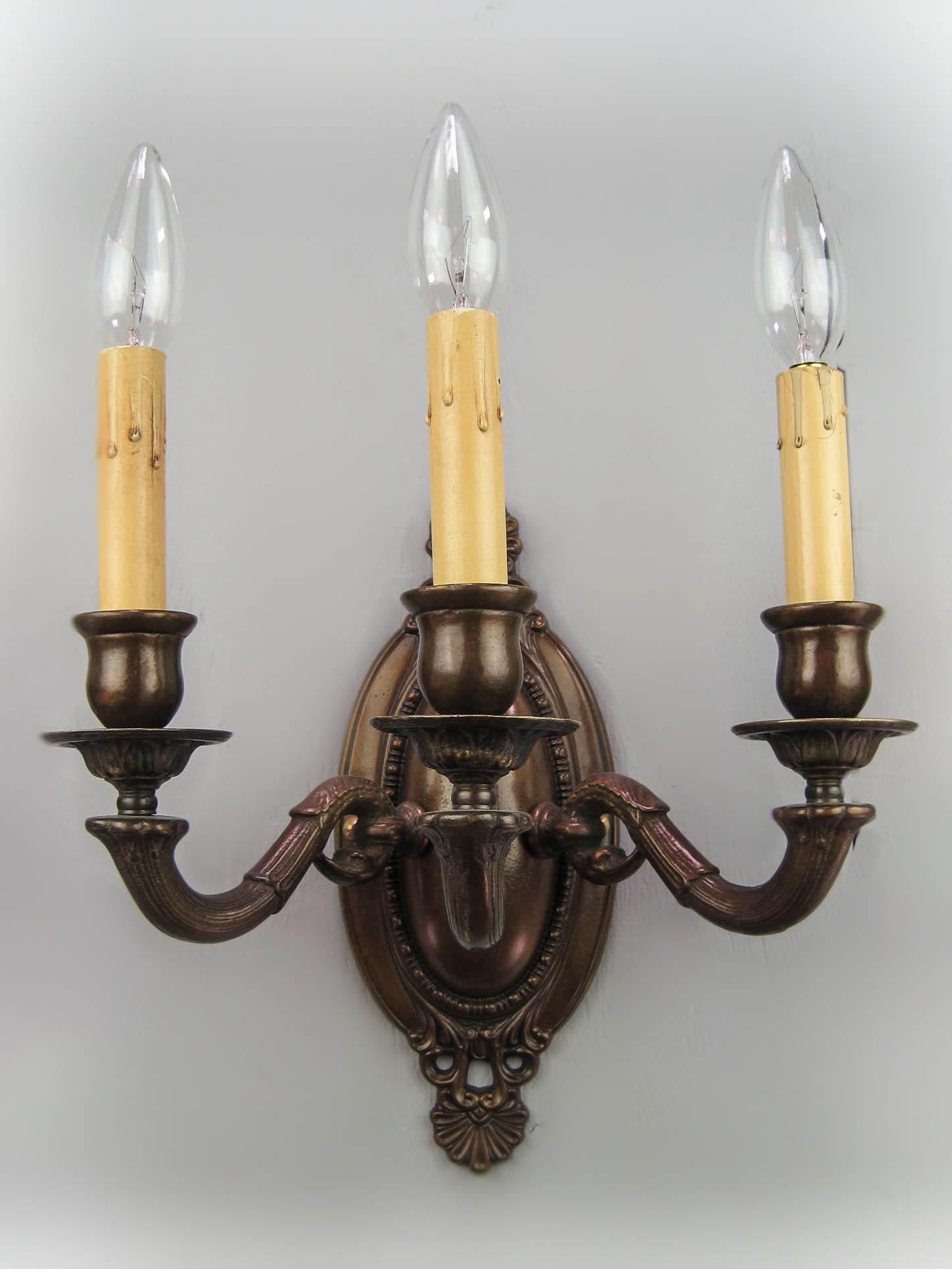 Edwardian 'Dolphin' Wall Sconce (Triple Arm): New Re-cast Edwardian wall sconce with stylized dolphin arms, reproduced from original designs, circa 1905. This sconce is fitted with candle type holders. 10.5"L x 4.25"W (back plate) x 6"D, arm span