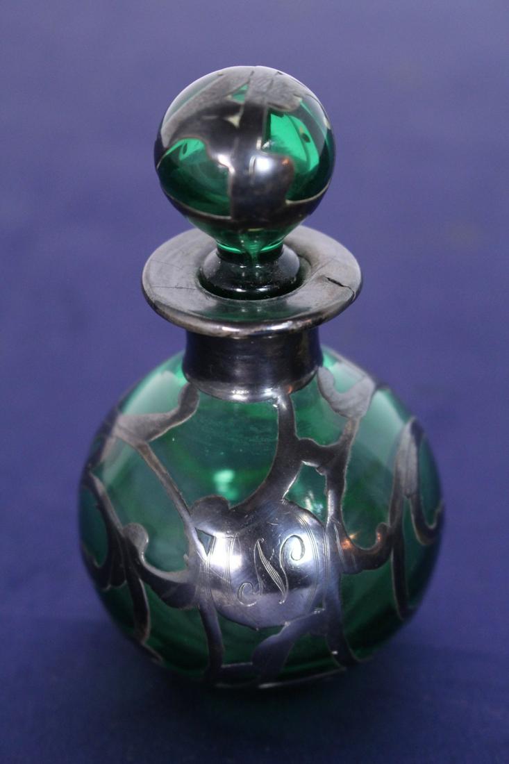 Green Glass and Silver Overlay Perfume Bottle: Green Glass and Silver Overlay Perfume Bottle with Stopper. The letter "N" is engraved in the overlay. 3.5"H x 2"D.