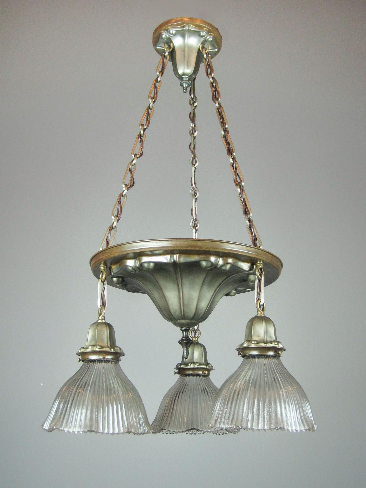 Art Nouveau Shower Light Fixture (3 Light): Ca. 1910 A shower light fixture embossed with an Art Nouveau style pattern on all the original parts. Three decorative chains suspend the body with matched bell shade holders fitted with antique ruffl