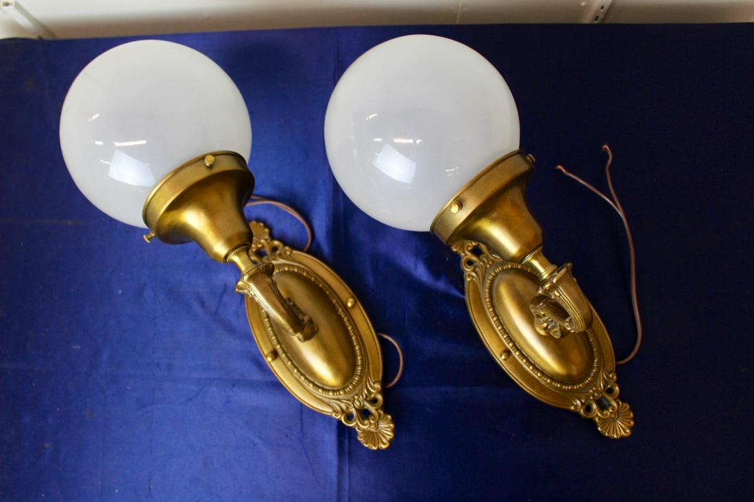 Edwardian Style Wall Sconces with Globe Shades: Edwardian wall sconces with frosted white globe shades. Depth of each sconce measures 8". Shade measures 6" Dia.