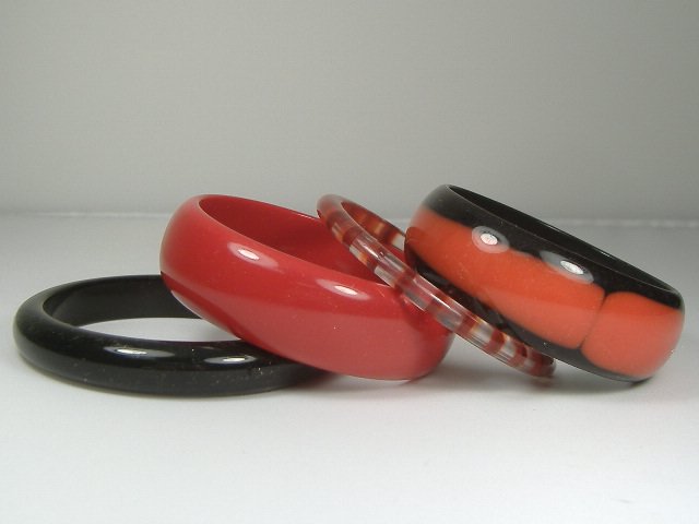 Vintage Lucite Set of 4 Ruby/Onyx Bangle Bracelets: For auction, a set of 4 vintage lucite ruby/onyx colored bangle bracelets. These bangle range in width from approx. 1/4 inch to approx. 1 inch. Their diameter are all approx. 2 3/4 inches. They do not