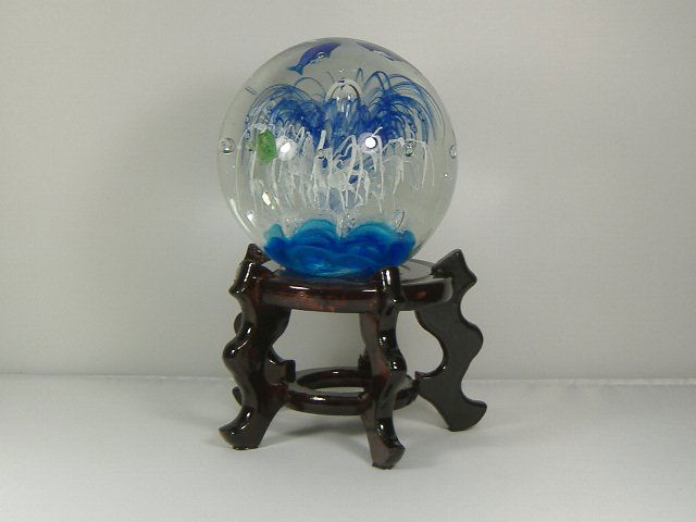 Ann Primrose Tropical Sea Life Paperweight on Stand: For auction, an amazing intricate work of art. This tropical sea life paperweight is designed with very detailed sharks, fish, and plant life. The paperweight measures approx. 4 1/2 inches in diameter