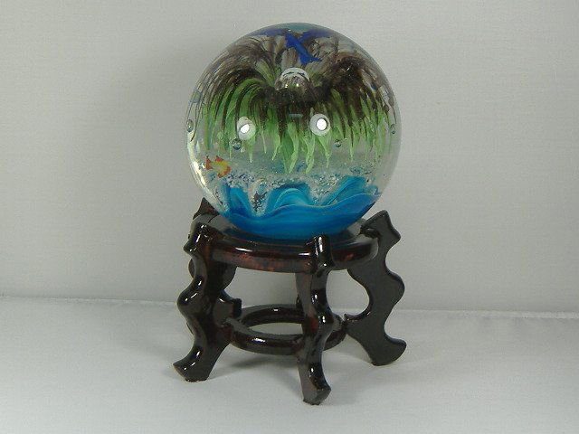 Ann Primrose Tropical Sea Life Paperweight on Stand: For auction, an amazing intricate work of art. This tropical sea life paperweight is designed with very detailed sharks, fish, and plant life. The paperweight measures approx. 4 1/2 inches in diameter