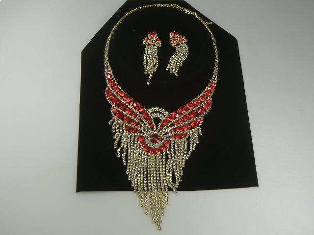 Ruby Swarovski Crystal Necklace and Earring Set: For auction, a truly amazing swarovski necklace and earring set. The earrings are post style and displays ruby and clear colored stones with a gold tone base.