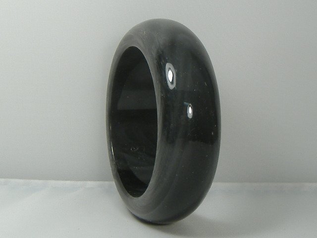 Vintage Lucite Charcoal Bangle Bracelet: For auction, a very unique lucite vintage bangle bracelet. It features a very dark charcoal design. Measures approx. 1 inch in width and approx. 2 3/4 inches in diameter. It does not adjust to fit dif