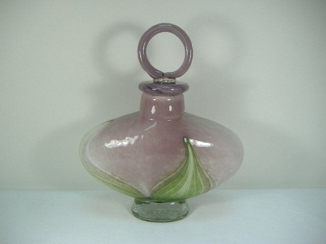 Ann Primrose Murano Collection Amethyst Perfume Bottle: For auction, a remarkable art glass perfume bottle. This piece features a feather design with emerald coloring upon an amethyst base. It measures approx. 9 1/2 inches in length, approx. 3 1/2 inches i