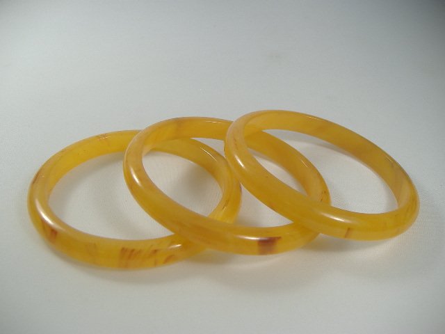 3 Vintage Lucite 1970's Butterscotch Bangle Bracelets: Manufactured by Best Plastics of Providence RI in the 1970s. Each measure approx. 1/2 inch in width and approx. 2 3/4 inches in diameter.