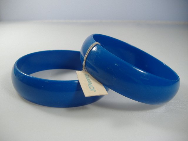 2 Vintage Lucite 1970s Sapphire Bangle Bracelets: Manufactured by Best Plastics of Providence RI in the 1970s. Each Measures approx. 1 inch in width and approx. 2 3/4 inches in diameter.