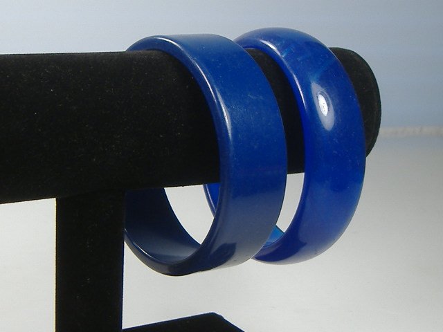 2 Vintage Lucite 1970s Sapphire Retro Bangle Bracelets: Excellent condition! Manufactured by Best Plastics of Providence RI in the 1970s. Original Stock. Measures Approx. 1 inch in width and approx. 2 3/4 inches at their maximum diameter.