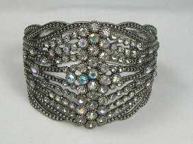 Crystalleria Designer Bangle Bracelet: From the Ann Primrose Collection comes this opportunity to own a masterpiece! Chunky, Attention grabbing, and sleek, this bangle will be the talk of any gathering! The angular crystals glare as light 