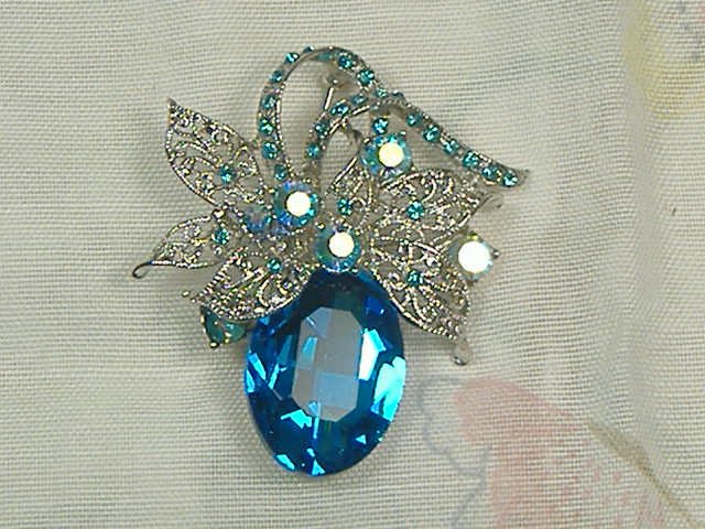 Swarovski Crystal Element Pin Brooch: Chunky, Attention grabbing, and sleek, this pin will be the talk of any gathering! The angular crystals glare as light hits their surface at different angles. Caste in molten metal, formed, high quali