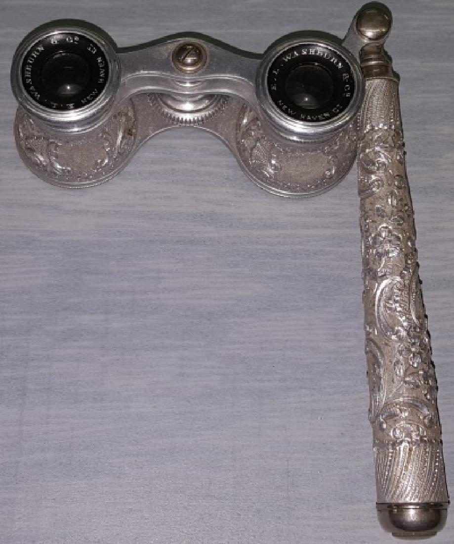 *PAIR OF RARE ALUMINUM OPERA GLASSES: Aluminum lorgnette, having detailed floral and scroll repousse on handle and body, eye cups marked "EL Washburn & Co. New Haven, CT", with telescopic handle.