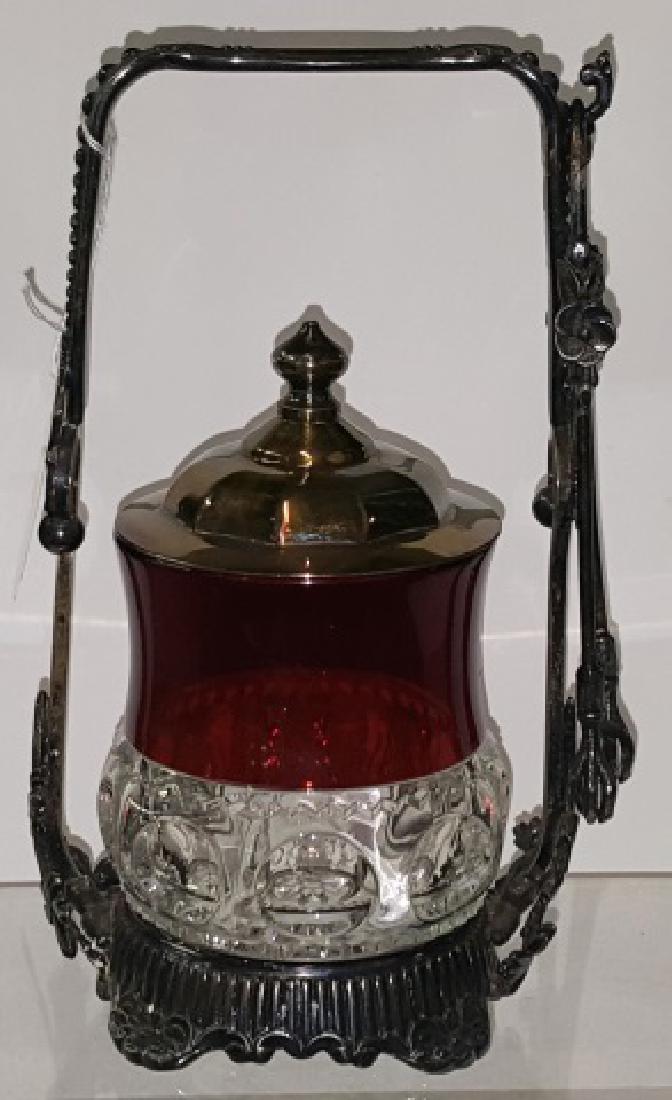 *VICTORIAN PICKLE CASTOR: Having cranberry to clear glass jar, with silverplate stand, complete with tongs, approximate height 8 3/4".
