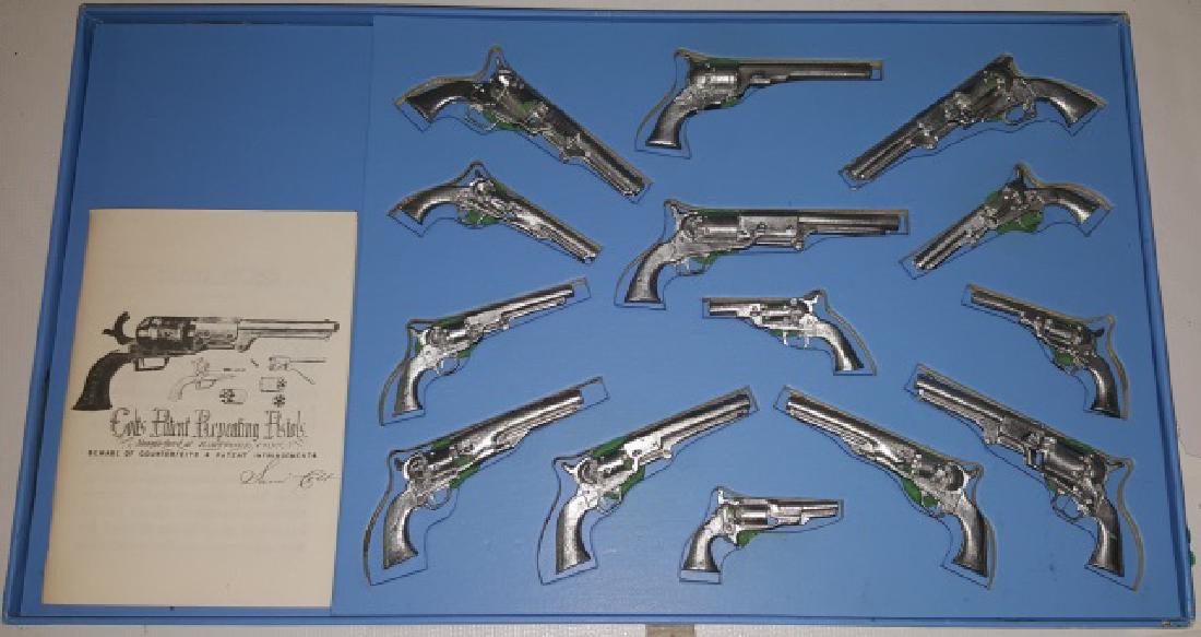 SET OF MINIATURE LEAD COLT REPEATING PISTOLS: In display, complete with pamphlet, approximate frame length 12".