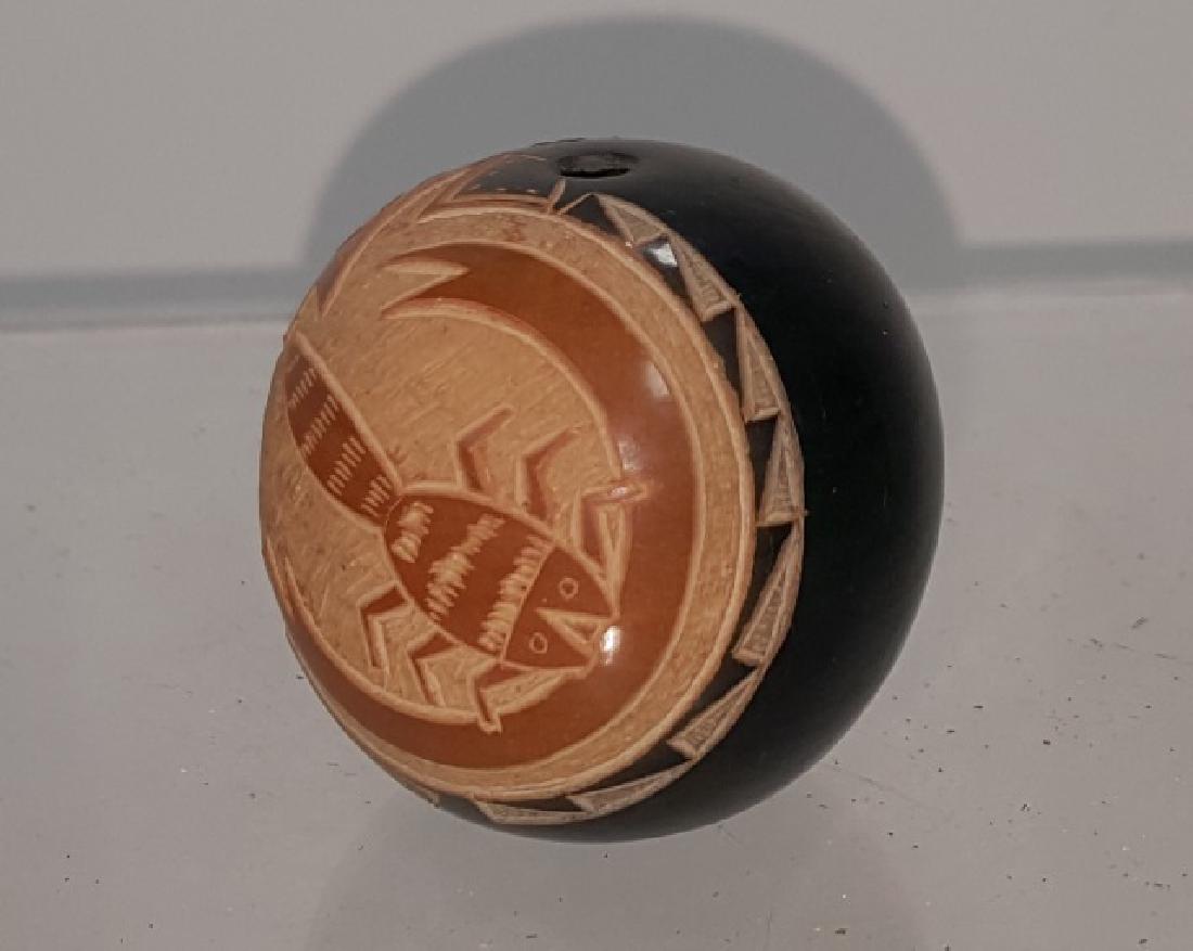 *ART CODI BLACKWARE SEED JAR: San Ildefonso Pueblo seed jar, 1 half black, 1half sgrafitto carving depicting fish chasing water bug, signed on bottom "Haungooah", approximate height 1 1/4", diameter 1 1/4".