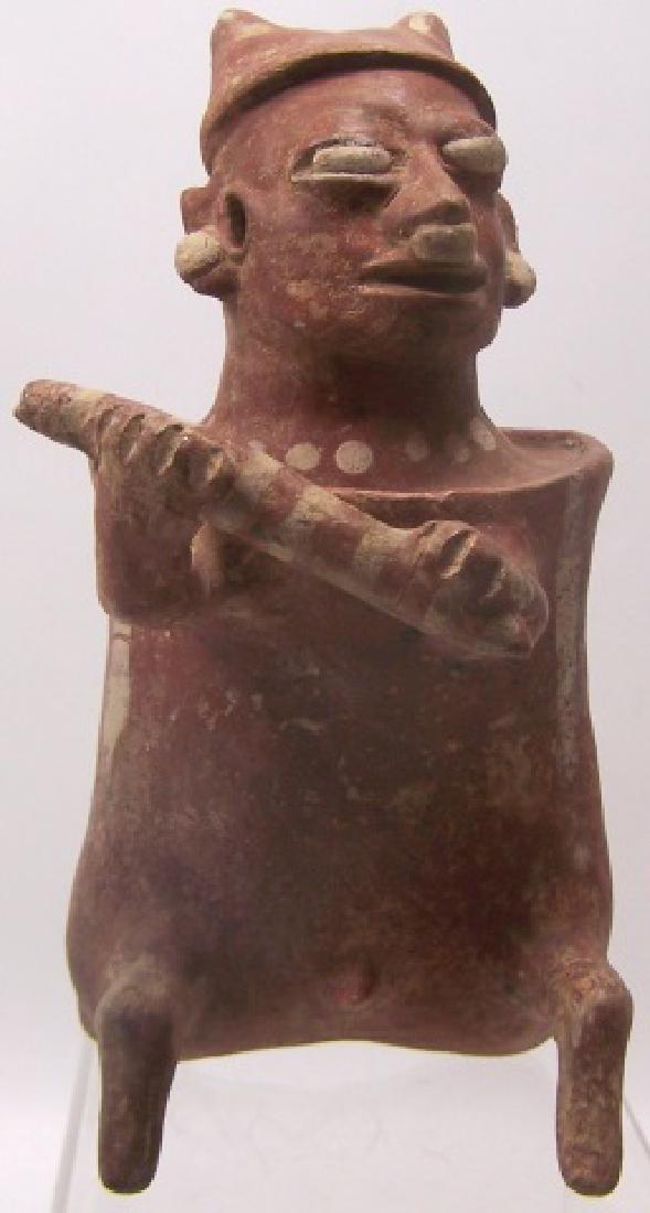 *PRE-COLUMBIAN POTTERY FIGURE: Seated man with flute, with painted decoration, approximate height 7".