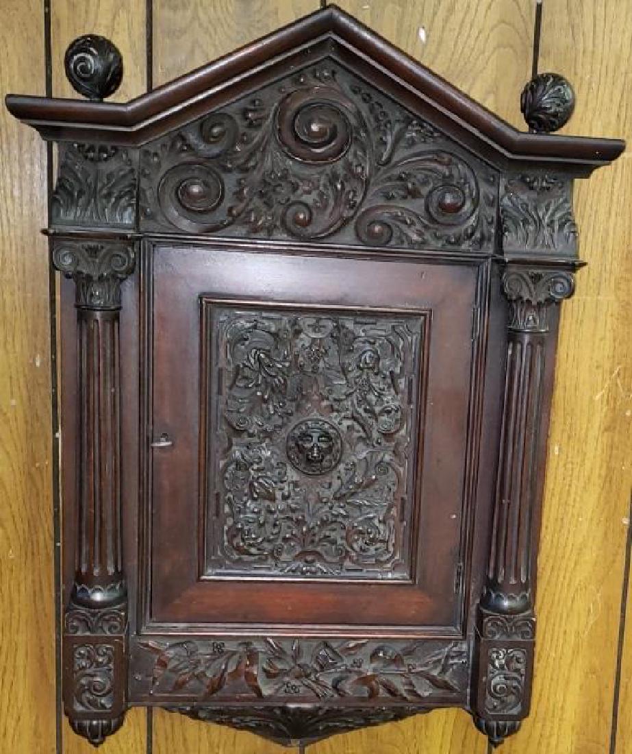 *19TH C. WALL MOUNT CABINET: Having heavily carved decoration depicting lion mask, leafy scrollwork, and bowed ribbon, approximate height 32", width 23", depth 8".