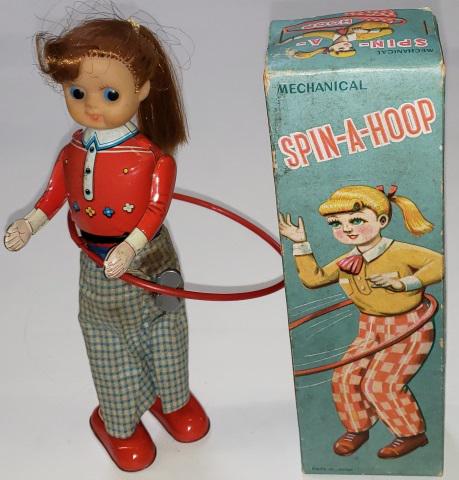 TIN WIND-UP TOY: Spin-a-Hoop, tin body with rubber head, with original box, approximate height 8 3/4".