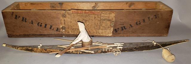 *INUIT CARVING: Depicting figure in kayak rowing with hunting tools, made from wood, hide, and bone, approximate length 18 1/2", comes with original shipping box with Customs declaration dating June 10, 1942.