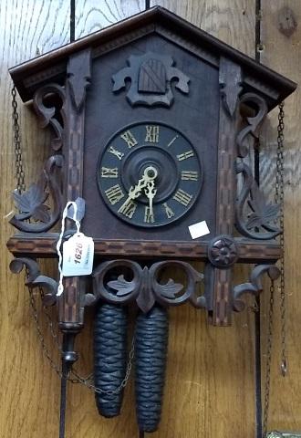 GERMAN CUCKOO CLOCK: Fitted with time and strike movement, wood dial having Roman numeral markers, enclosed in carved oak case.