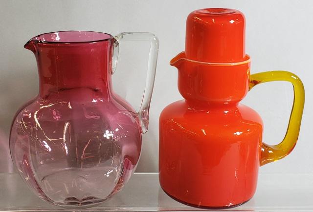 2 PIECES: Cranberry glass pitcher with applied clear glass handle, approximate height 7 3/4", and a tumble up with red ground and amber glass handle, height 8 1/2".