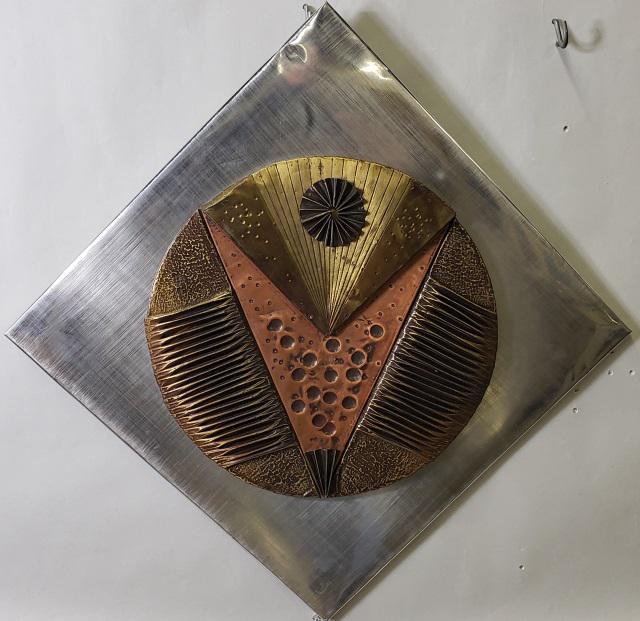 *PAUL VANDERS BRUTALIST WALL SCULPTURE: Paul Vanders (20th C. American), abstract circle, framed mixed media sculpture comprised of brass, copper, and aluminum folded over plywood panel, having silvered metal frame, approximately 20" x 20".