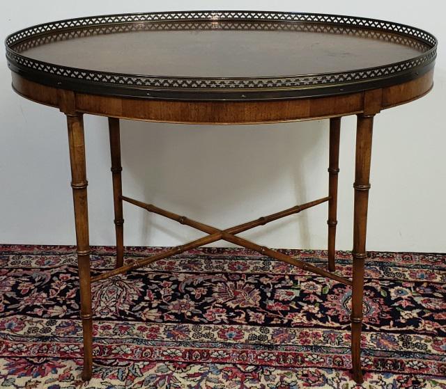 *PERIOD STYLE LAMP TABLE: By Baker, having three-quarter brass gallery, raised on bamboo style legs, approximate height 22 1/2", width 30", depth 21 3/4".