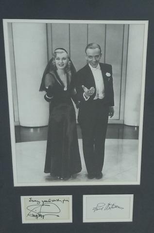 *FRED ASTAIRE AND GINGER ROGERS AUTOGRAPHS: Professionally framed and double matted b/w photo, 13 1/4" x 10", and two individually matted 3 1/2" x 2" autographs. Overall piece measures 15" x 22". Signature, Fred Astaire, Inscription, Every good