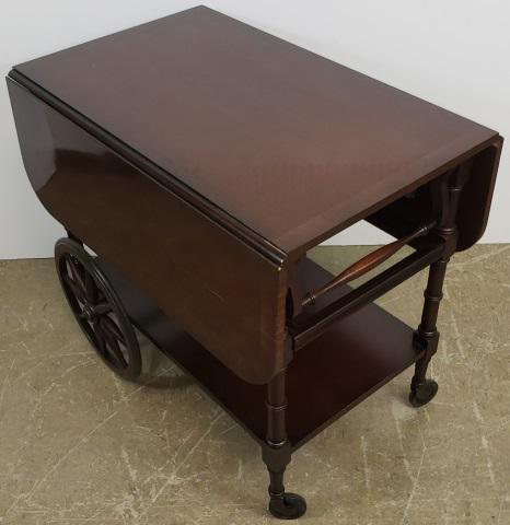 *PERIOD STYLE TEA CART: By Baker, having drop leaves over single drawer with platform stretcher below, approximate height 29", width 32", depth 42".