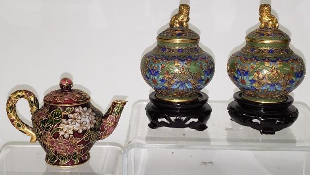 *3 PIECES OF CHAMPLEVE: 2 small covered urns having lids decorated with foo dogs on circular wood stands, approximate height with stand 4 3/8", and a teapot with floral decoration, height 3".
