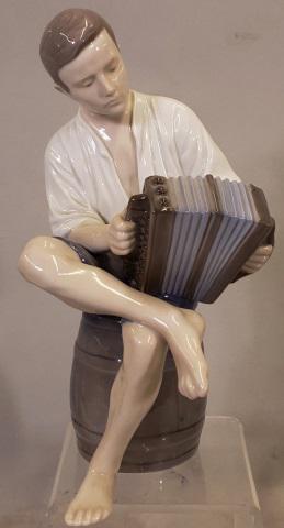 *BING & GRONDAHL PORCELAIN FIGURE: Seated boy playing according, no. 1661, approximate height 8 3/4".